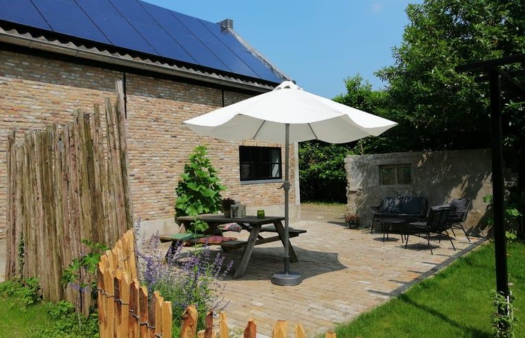 Sunny terrace with parasol at Cottage in Kaatsheuvel, vacation home in North Brabant.