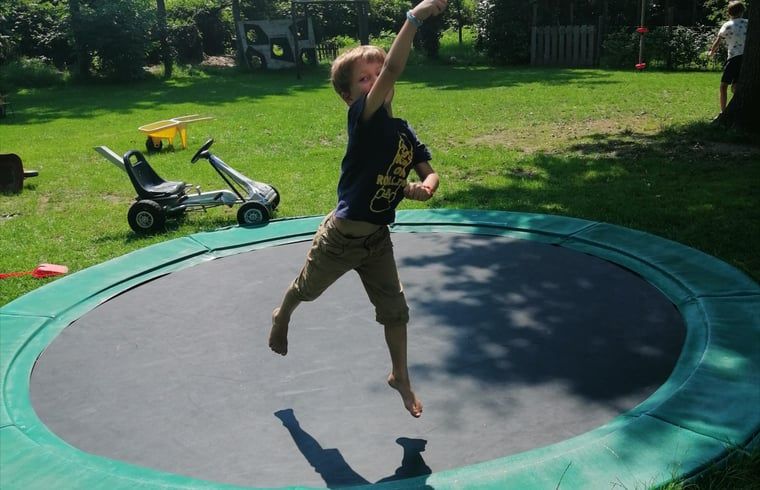 Children play on trampoline at Cottage in Kaatsheuvel, vacation home in North Brabant.