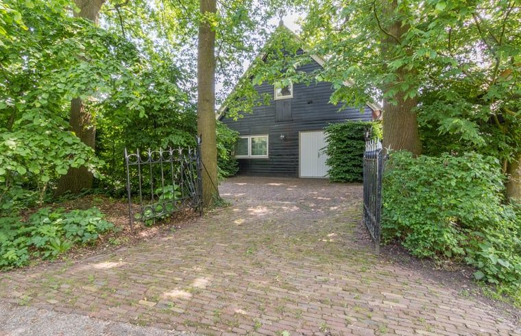 Vakantiehuisje in Sleeuwijk omringd door groene natuur, ideaal voor een ontspannen verblijf in Hart van Brabant, Noord Brabant.