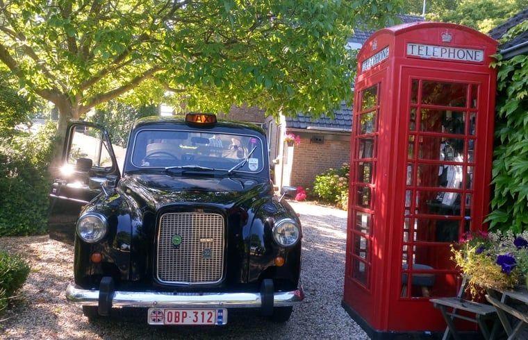 Authentic cab at Huisje in Hank, vacation home in Hart van Brabant, North Brabant, with English phone booth.