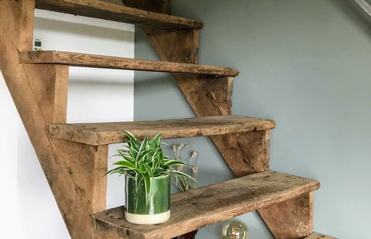 Houten trap in Vakantiehuisje in Gemonde, een charmant detail in Noord Brabant.