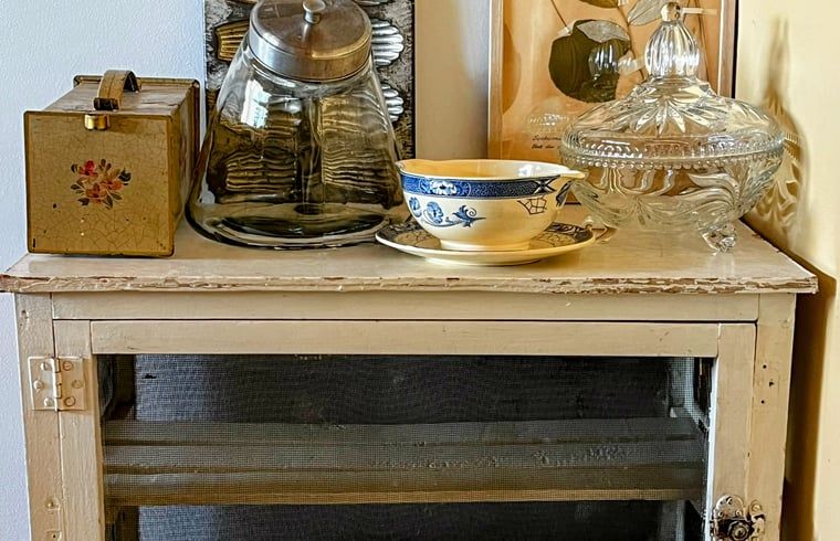 Antieke kast met servies in Vakantiehuisje in Gemonde, een nostalgisch tintje in Noord Brabant.