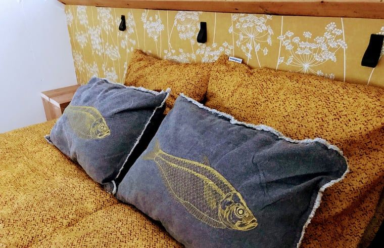 Comfortabel bed met kussens in Vakantiehuisje in Gemonde, een rustgevende slaapervaring in Noord Brabant.