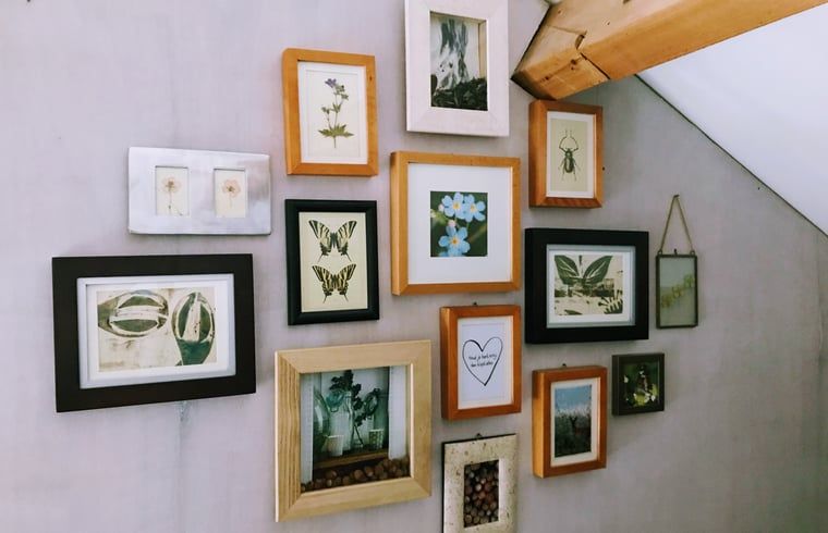 Wand met fotolijsten in Vakantiehuisje in Gemonde, een persoonlijke touch in Noord Brabant.