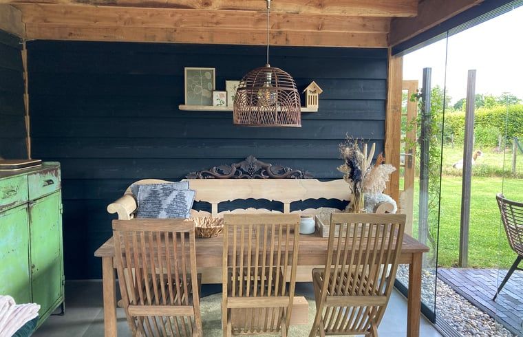 Gezellige eethoek in de tuin van Vakantiehuisje in Gemonde, ideaal voor buiten dineren in Noord Brabant.