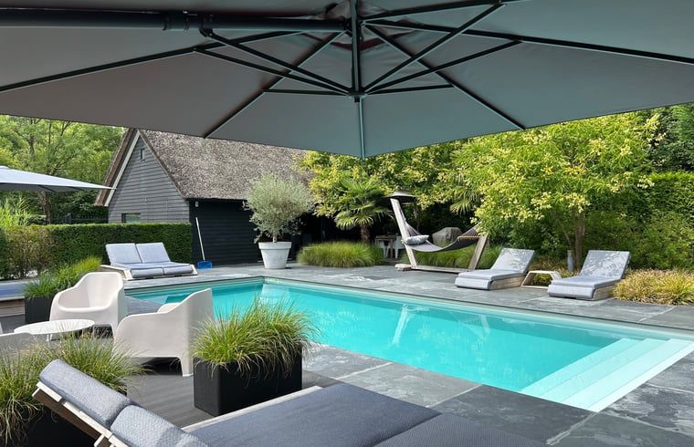 Ontspan bij het zwembad van Huisje in Boxtel, een charmante vakantiewoning in het hart van Noord Brabant, omringd door groen en rust.