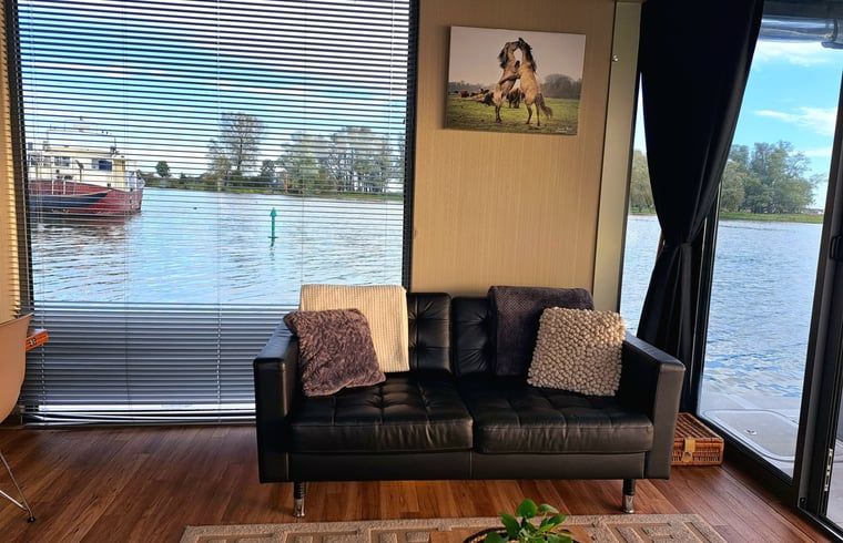 Gemuetliche Sitzecke mit Blick auf das Wasser im Cottage in Woudrichem, Nordbrabant.