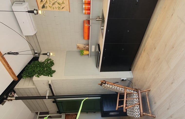 Lichte woonkamer in Vakantiehuisje in Tilburg met uitzicht op de tuin.