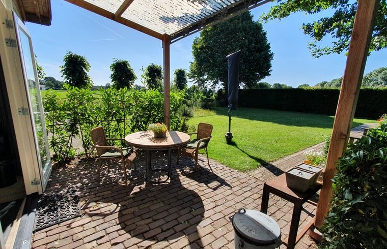 Zonnig terras bij Vakantiehuisje in Tilburg, ideaal voor ontspanning.