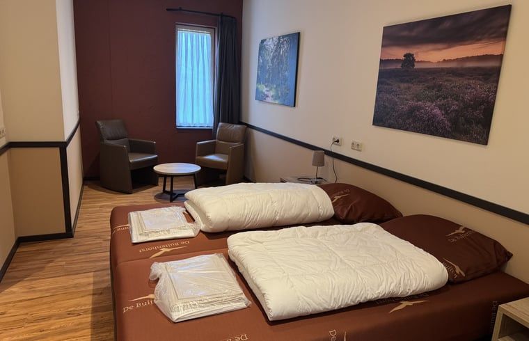 Comfortabele slaapkamer met kunst aan de muur in Vakantiehuis in Schaijk, Noord Brabant.