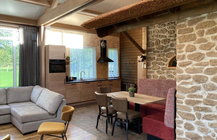 Gezellige binnenruimte met houten balken in Vakantiehuis in Schaijk, Noord Brabant, perfect voor familiebijeenkomsten.