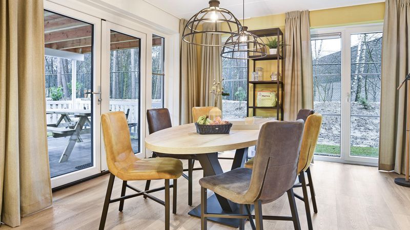 Eetkamer met uitzicht op natuur in De Vers 6-persoons bungalow Overloon, Noord Brabant.