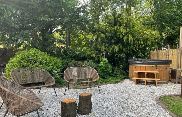 Gezellige zithoek in de tuin van Vakantiehuis in Overloon, omgeven door natuur in Noordoost Brabant.