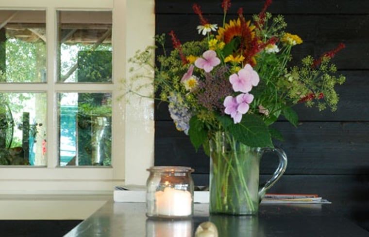 Bloemen in een vaas binnen Vakantiehuis in Oeffelt, Noord Brabant, met sfeervolle inrichting.