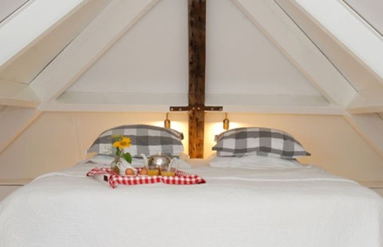 Knusse slaapkamer met houten balken in Vakantiehuis in Oeffelt, Noord Brabant.