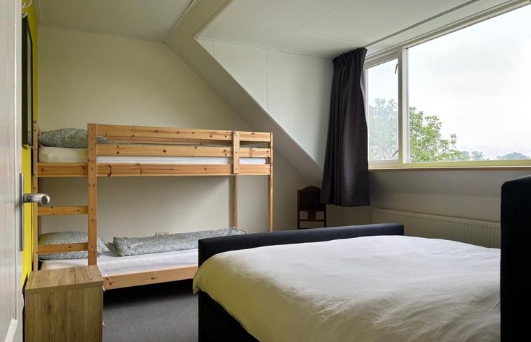 Gemuetliches Schlafzimmer mit Doppelbett in einem Ferienhaus in Gemert, Nordost-Brabant.