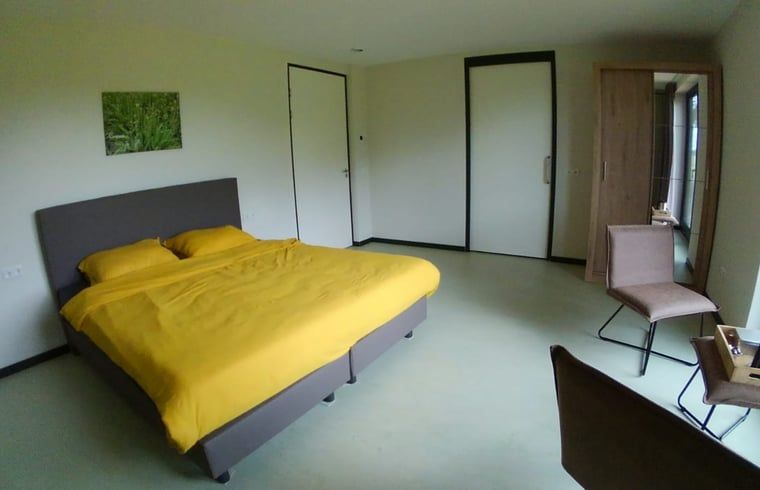 Comfortabele slaapkamer in Vakantiehuis in Erp, Noord Brabant, met geel beddengoed.