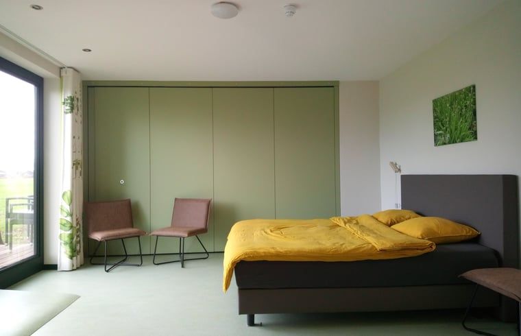 Lichte slaapkamer in Vakantiehuis in Erp, Noord Brabant, met groene accenten.