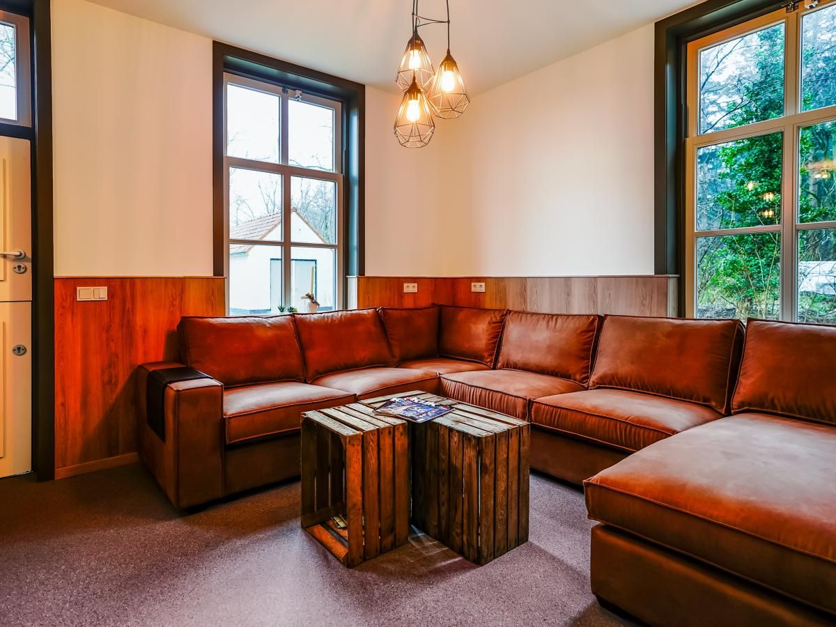 Gezellige woonkamer in vakantiehuis Bosbeertje 43 45, Erp, Noord Brabant met comfortabele bank en natuurlijke lichtinval.