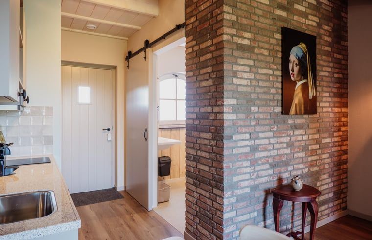 Binnenruimte van Vakantiehuis in Sint-Oedenrode, Noordoost Brabant, met een gezellige bakstenen muur en moderne keuken.