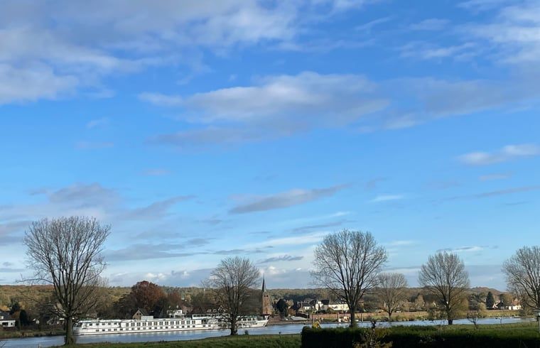 Gezellige woonkamer in Vakantiehuis in Katwijk NB, Noordoost Brabant met comfortabele banken en een houtkachel voor een knusse sfeer.