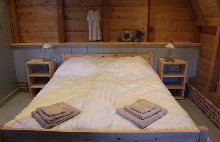 Gezellige slaapkamer in vakantiehuisje in Breda met houten interieur, West Brabant, Noord Brabant.