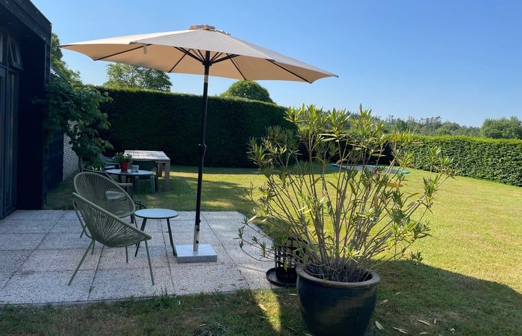 Veranda met parasol bij Vakantiehuisje in Breda, West Brabant.