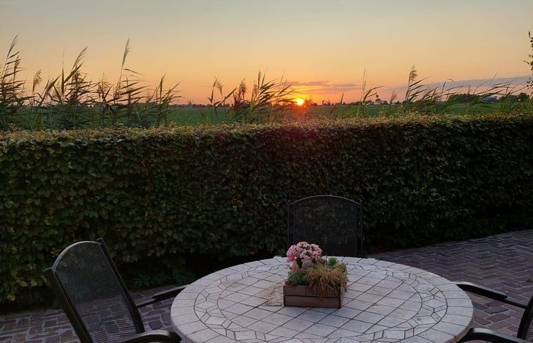 Terras bij zonsondergang bij Vakantiehuisje in Ossendrecht, West Brabant.
