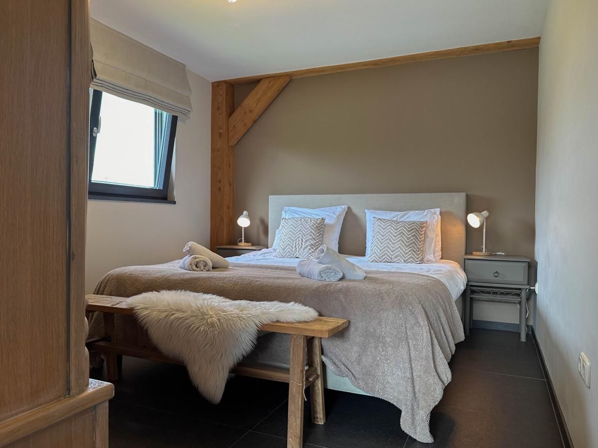 Comfortable bedroom with wooden accents in Villa Bianco, Alphen.