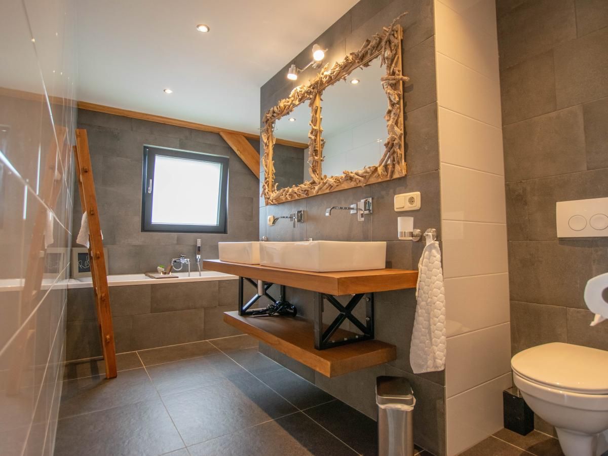 Stylish bathroom with bathtub in Villa Bianco vacation home, Alphen.