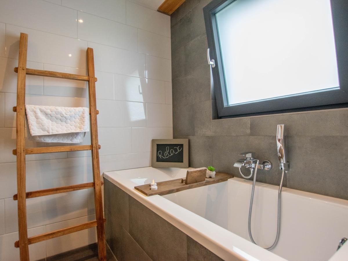 Luxury bath with wooden ladder in Villa Bianco vacation home, North Brabant.