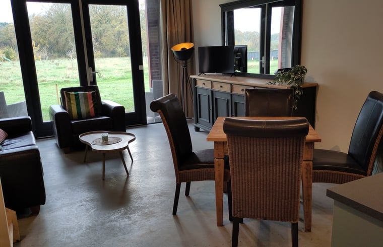 Gemuetlicher Innenbereich des Huisje in Rucphen, Ferienhaus in Westbrabant, mit Holztreppe, moderner Kueche und Essbereich.