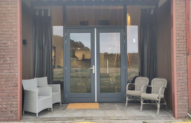 Eingang zum Cottage in Rucphen, einem modernen Ferienhaus in Westbrabant, Nordbrabant, mit Blick auf die Natur vom Flur aus.