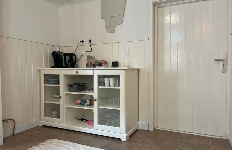 Kuechenzeile im Ferienhaus in Hoogerheide, West-Brabant mit Kaffeemaschine und Glasvitrine.