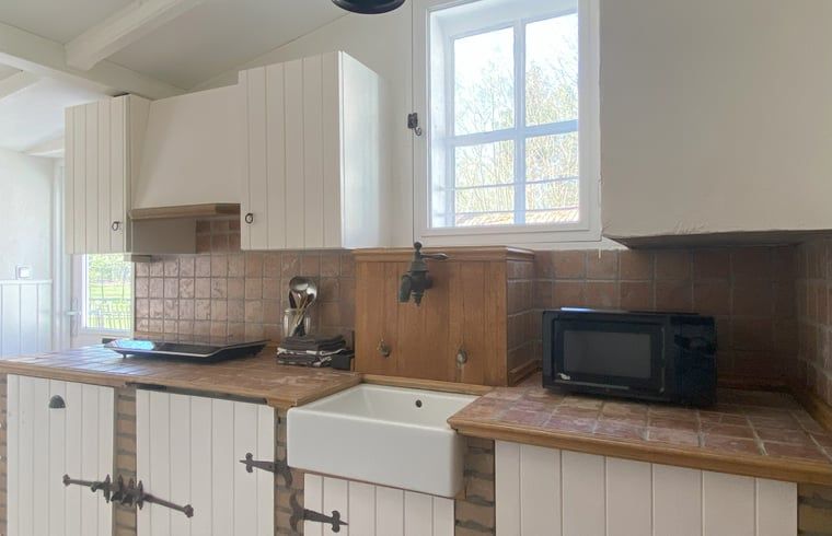 Landhauskueche in Hoogerheide, Nordbrabant, mit Holzarbeitsplatte und modernen Geraeten.