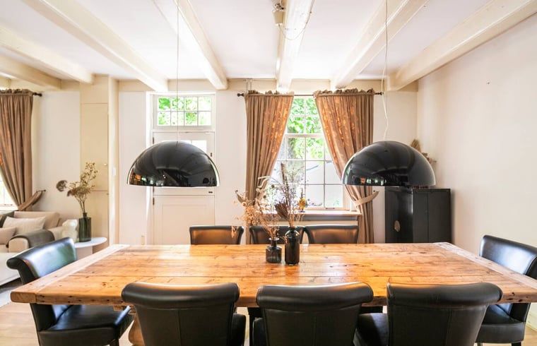 Elegante eetkamer met houten tafel in vakantiehuis in Roosendaal, West Brabant.
