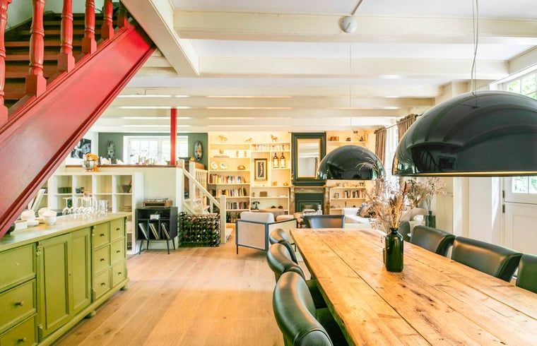 Stijlvol interieur met rode trap in vakantiehuis in Roosendaal, Noord Brabant.