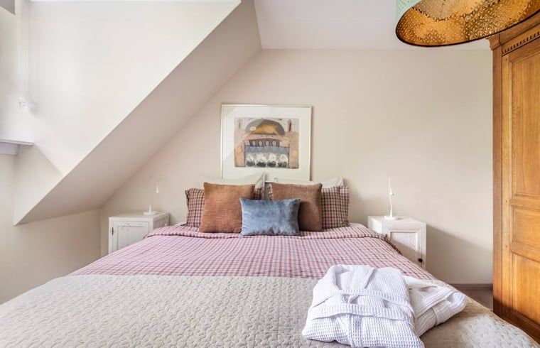 Slaapkamer met houten meubels in vakantiehuis in Roosendaal, West Brabant.