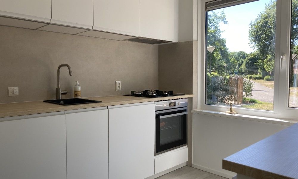 Moderne keuken in Villa Wellness Retreat, vakantiehuis in Halderberge, Noord Brabant, met uitzicht op groene omgeving.