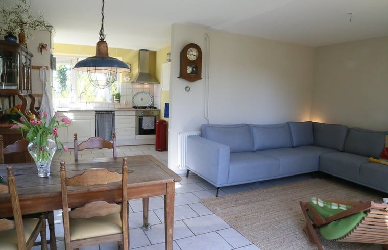 Geraeumiges Wohnzimmer im Ferienhaus in Oosterhout, Westbrabant, mit bequemer Sitz- und Essecke.