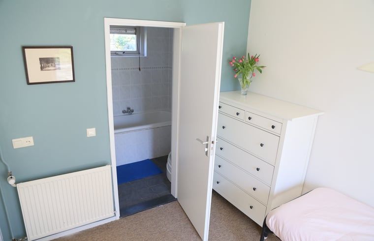 Stilvolles Schlafzimmer mit Zugang zum Badezimmer im Ferienhaus in Oosterhout, Nordbrabant.