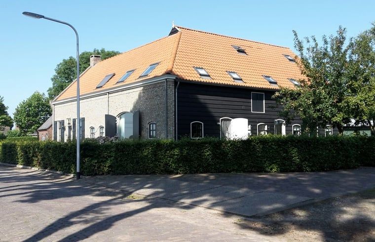 Ferienhaus in Drimmelen, West-Brabant mit charmanter Fassade und orangefarbenen Dachziegeln.