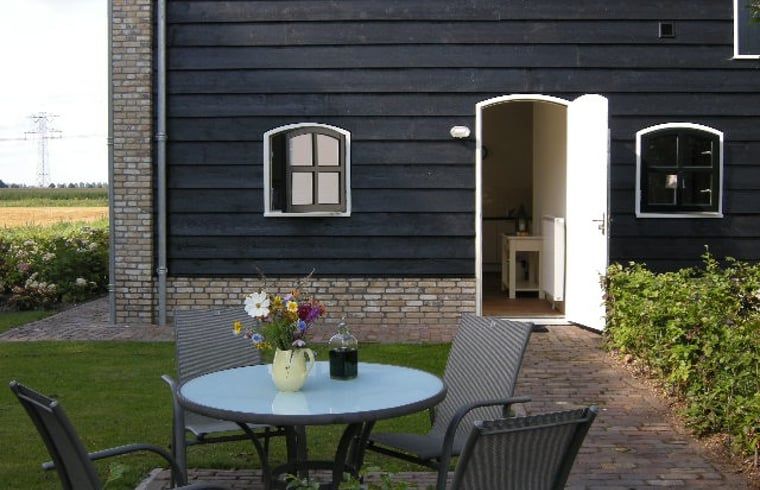 Terrasse von Haus in Drimmelen, Ferienhaus in Nordbrabant mit Sitzecke und gruener Umgebung.