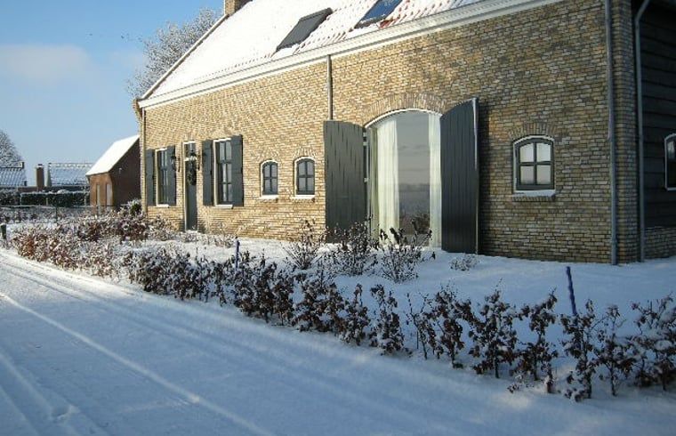 Verschneite Landschaft am Haus in Drimmelen, einem Ferienhaus in Westbrabant mit charmanter Backsteinfassade.