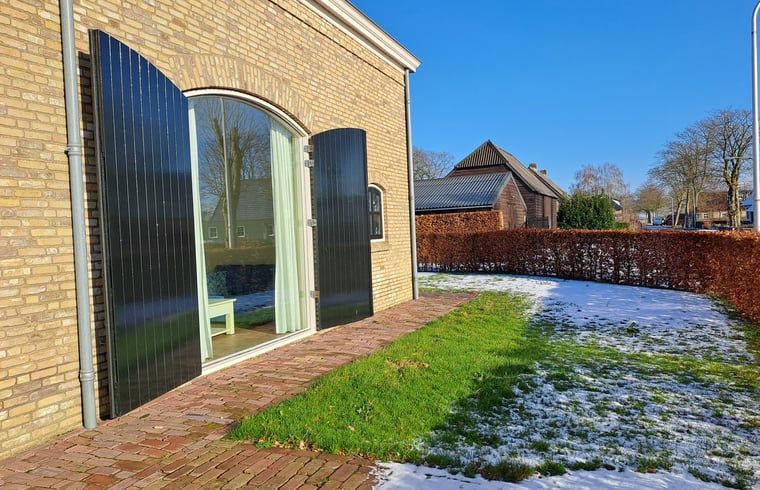 Sonnige Winterterrasse im Huisje in Drimmelen, Ferienhaus in Nordbrabant mit gruenen Akzenten.