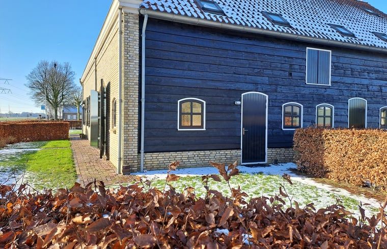 Seitenansicht von Haus in Drimmelen, Ferienhaus in Westbrabant mit Holzfassade und Wintergarten.