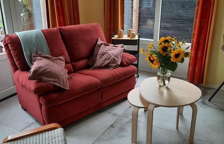 Cozy living room with red sofa in Holiday home in Werkendam, West Brabant, North Brabant