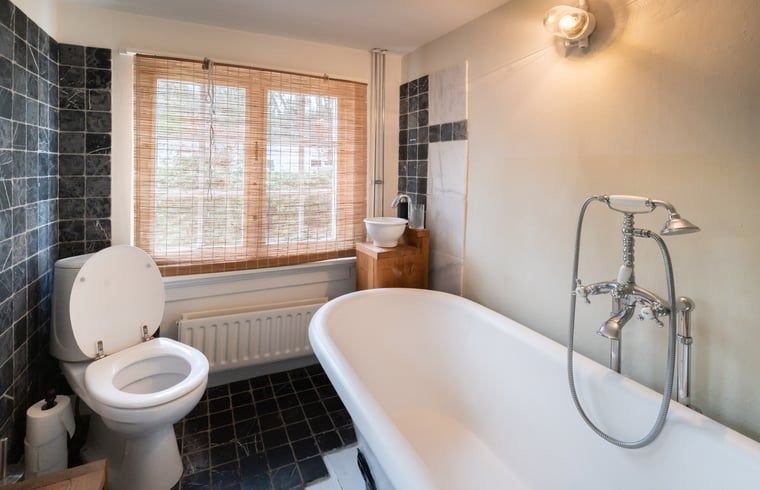 Elegante badkamer met bad in Huisje in Putte, vakantiehuis in West Brabant, Noord Brabant.