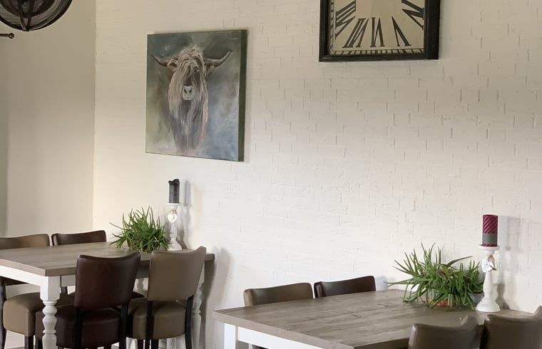 Stylish dining space in Cottage in Terheijden, West Brabant, with art and comfortable seating.