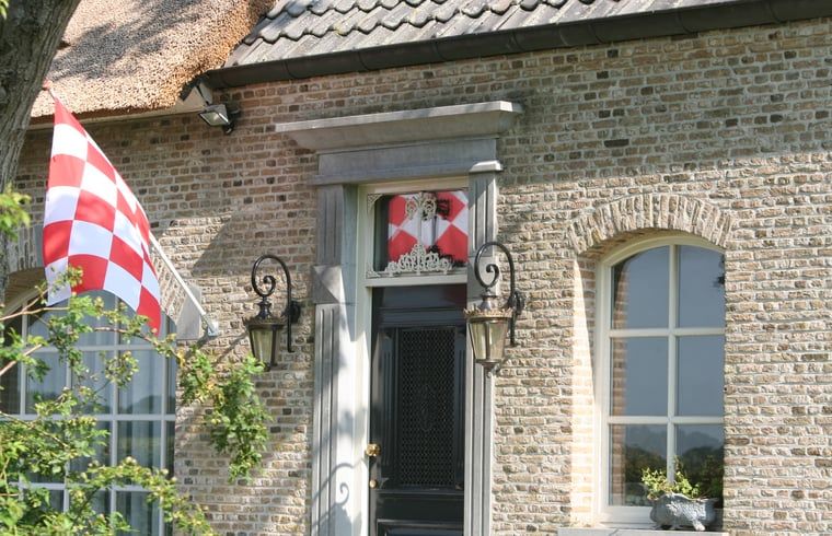 Charmante entree van Vakantiehuisje in Moerstraten, West Brabant, met authentieke bakstenen en landelijke details.